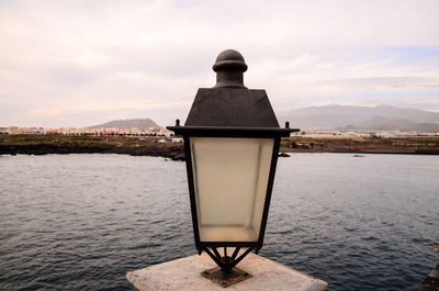 Rear view of man looking at sea against sky