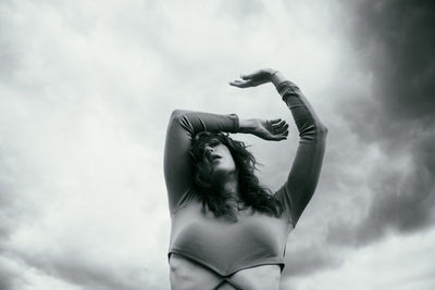 Low angle view of woman standing against sky