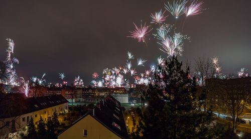 Firework display over illuminated buildings in city at night