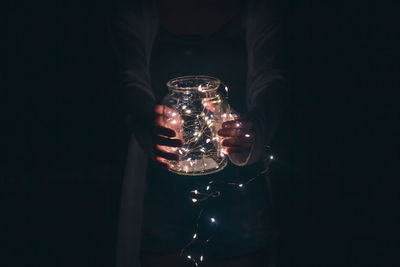 Person holding glass of illuminated lighting equipment