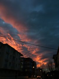 Low angle view of buildings against dramatic sky