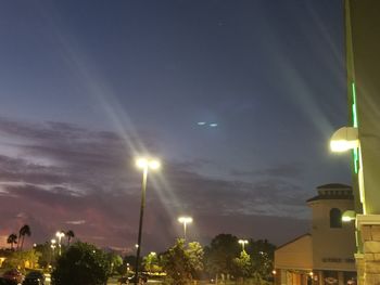 Illuminated city against sky at night