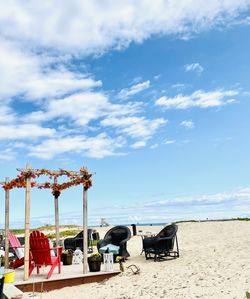 Chairs at beach against sky