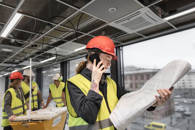 Female construction worker looking at blueprints