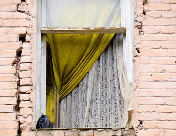 Low angle view of curtains seen through open window