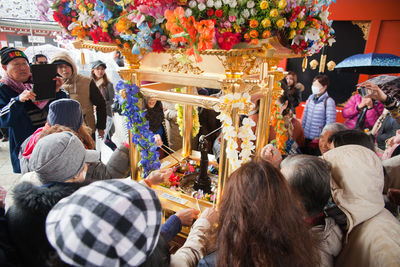 Crowd pouring water on buddha statue