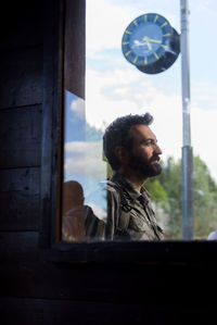 Smiling man looking away seen through window