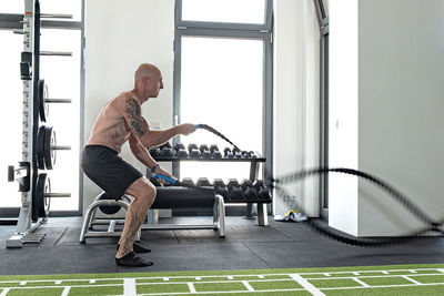 Side view of man exercising at gym