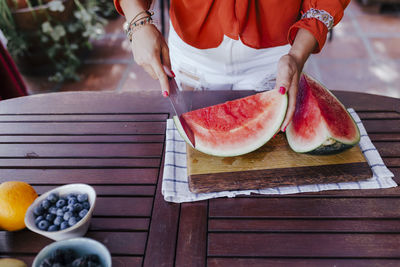 Midsection of man holding ice cream on table