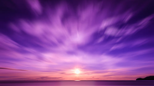 Scenic view of sea against dramatic sky during sunset