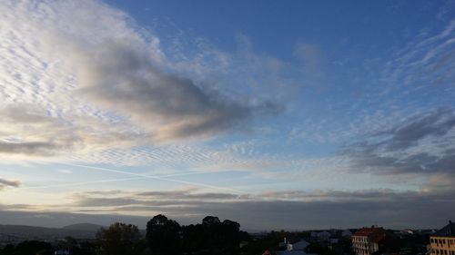 Low angle view of silhouette trees against dramatic sky