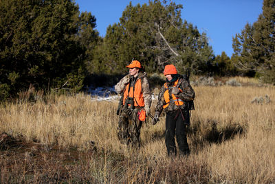 Two female hunters hike in a meadow in colorado