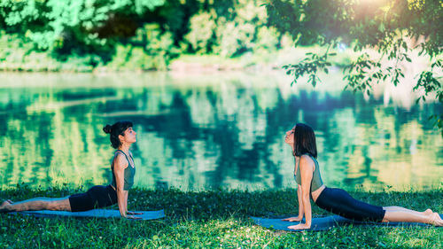 Yoga women by the lake. cobra pose