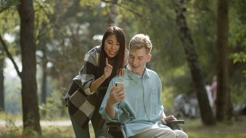 Man on wheelchair talking on video call with girlfriend at park