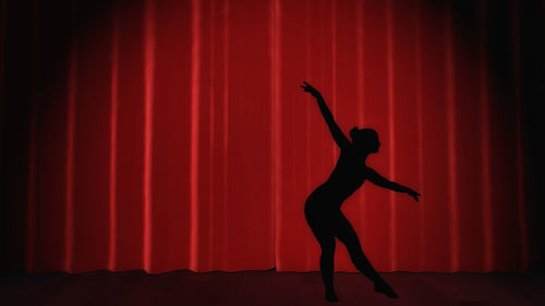 Full length of silhouette man standing on red stage