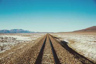 Railroad track against clear blue sky