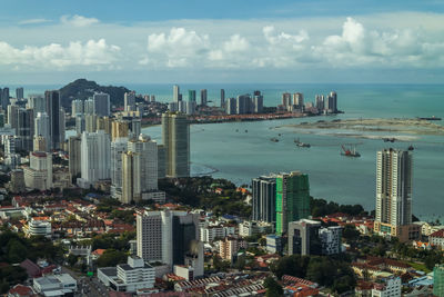 High angle view of buildings by sea against sky