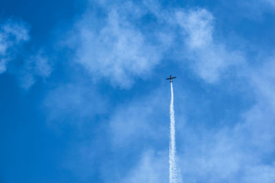 Low angle view of vapor trail against blue sky