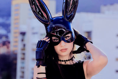 Portrait of woman wearing mask standing outdoors