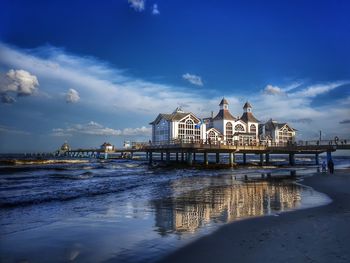 View of pier on beach against buildings