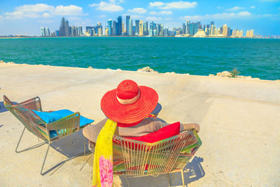 Woman sitting at beach in city