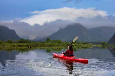 Red boat in lake against sky