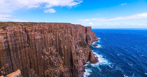 Scenic view of rock formation in sea against sky