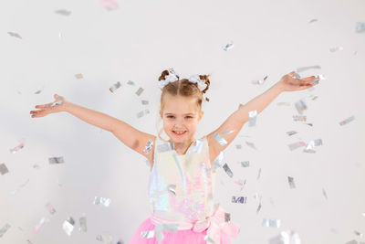 Portrait of cheerful girl standing against white background