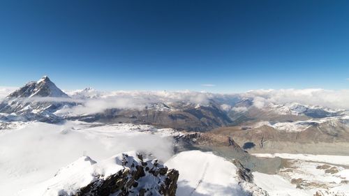 Idyllic shot of snowcapped mountains against blue sky