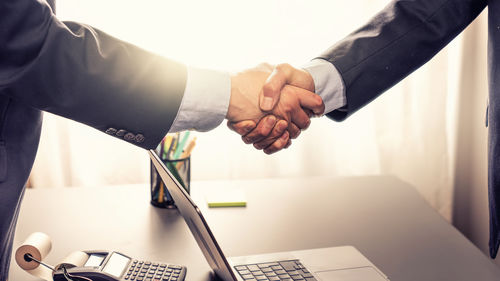 Cropped hands of businessman using laptop