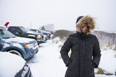 Woman preparing to go surfing during winter snow