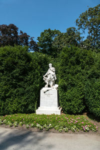 Statue by trees against sky