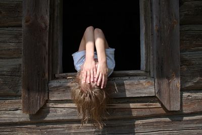 Low section of woman relaxing on wooden floor