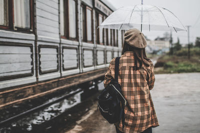 Rear view of woman with umbrella walking on rainy day