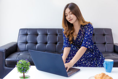 Young woman using phone while sitting on seat