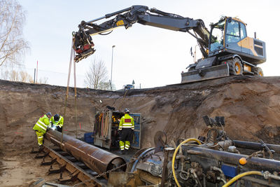 Construction machines with metal workers at site