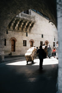 Rear view of people walking on street in city