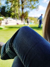 Midsection of person sitting on grass