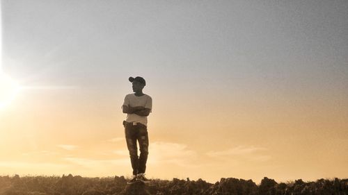 Silhouette man standing on field against clear sky