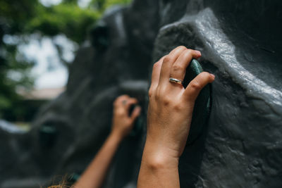 Cropped hand of woman climbing wall