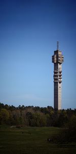 Lighthouse on landscape against blue sky