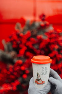 Close-up of hand holding drink against blurred background