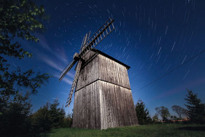 Traditional windmill on field against sky