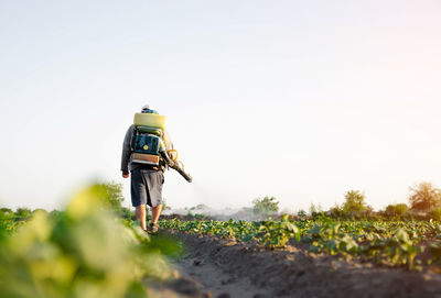 Farmer sprays pesticides on plantation. agriculture and agro industry. use of chemicals 