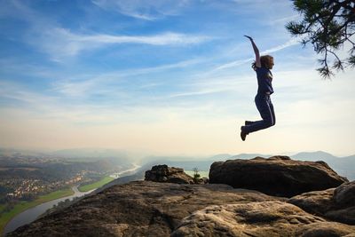 Woman jumping against sky