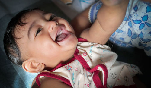 Portrait of cute baby lying on bed