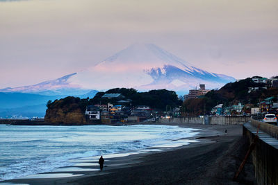 Scenic view of sea and snowcapped mountains against sky during sunrise