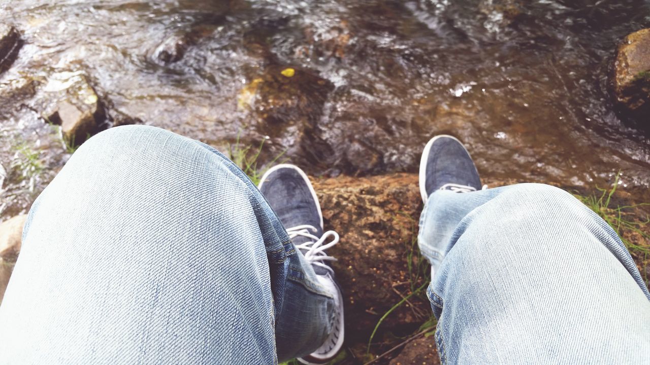 low section, person, shoe, personal perspective, water, lifestyles, human foot, footwear, high angle view, leisure activity, jeans, men, standing, relaxation, lake, sitting