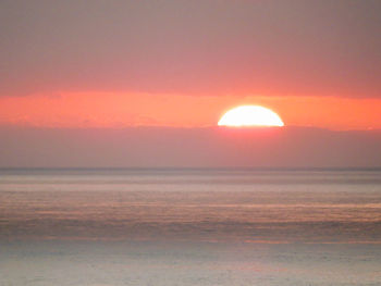 Scenic view of sea against orange sky