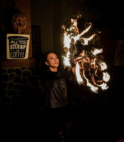 Portrait of young woman standing against wall